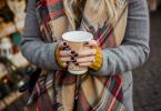 Frau mit Kaffeebecher in der Hand