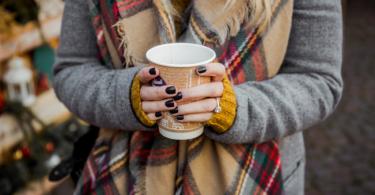 Frau mit Kaffeebecher in der Hand